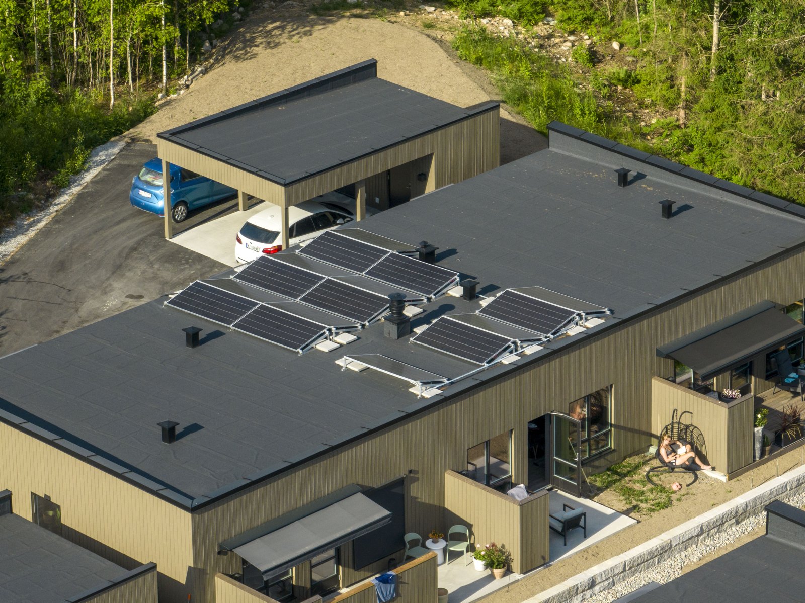 Dronebilde av solcellepaneler i rekker på et flatt tak